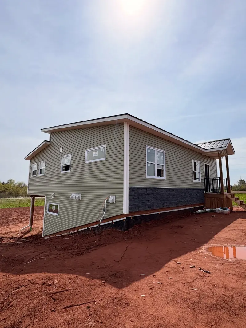 A newly built two-storey home with grey siding and a back deck