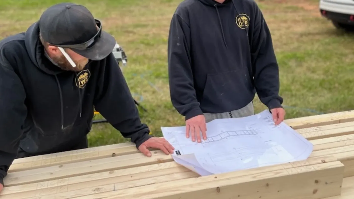 Two builders looking over house plans on site